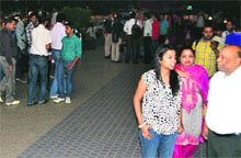 Shoppers wait outside Ansal Plaza as MC officials seal shops at the mall on the Ferozepur Road in Ludhiana on Tuesday.