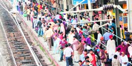 A large number of passengers wait for the arrival of their trains at the railway station in Amritsar on Thursday.