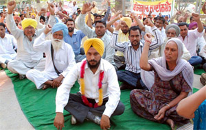 Unemployed linemen stage dharna outside the district administrative complex on Thursday. 
