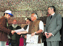 Union Minister for Rural Development Jairam Ramesh hands over a placement letter to a youth trained under the Himayat scheme in Pampore, near Srinagar, as Chief Minister Omar Abdullah looks on.