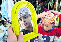 Children select caps ahead of Eid-ul-Azha at a market in Jammu on Thursday