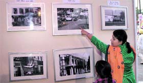 A woman shows a photograph of the 1984 carnage to her child during a photo exhibiton.