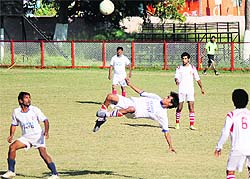 A football player makes an acrobatic attempt in a bid to score a goal during a football tournament in Srinagar on Thursday