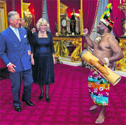 A traditional Papua New Guinean drummer performs for Britain's Prince Charles and his wife Camilla, Duchess of Cornwall, in London