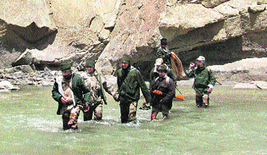 Indo-Tibetan Border Police personnel crossing a glacier-fed rivulet to reach a forward post along the Line of Actual Control in Ladakh.