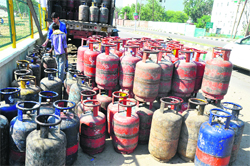 Workers unloading LPG cylinders on a roadside in Jammu. 