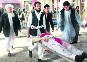 Afghans carry the body of a suicide attack victim in Maymana, north west of Kabul, on Friday. 