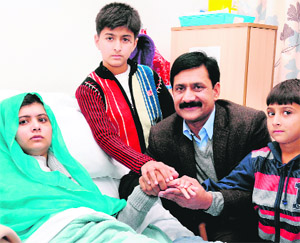 Pakistani schoolgirl Malala Yousafzai with her brothers and father Ziauddin Yousufzai at a hospital in Birmingham. 
