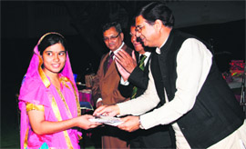 Food and Civil Supplies Minister Pritam Singh presents a merit certifiicate to a student of Shalini School, Beverly Hills, in Dehradun on Saturday. 