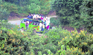 People travel on the roof of an overloaded mini-bus on Mathwar road near Jammu.