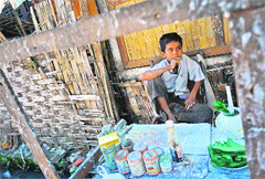 A Muslim Rohingya boy waits for customers at his stall in Aung Mingalar quarter in Sittwe on Saturday.  AFP