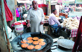 A man prepares a sweet product relished especially around Karva Chauth, at a shop near Sadbhavna Chowk in Bathinda on Sunday.