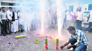 Congress workers burst crackers in Dehradun on Sunday. 