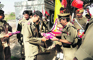 An officer of the Pakistan Rangers receives sweets from a BSF officer at a forward post along the international border in the Suchetgarh area on the occasion of Eid.