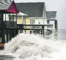 A wave crashes into the houses on the east side of Ocean Isle Beach in North Carolina. 