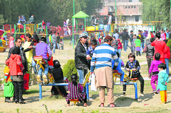 Families make the most of a holiday at amusement rides at a childrens park in Srinagar on Monday. 