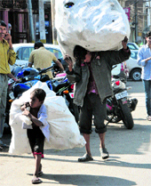Children are lifting heavy loads, looking for rags