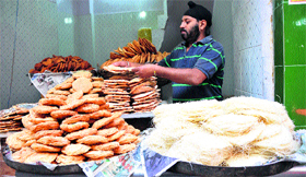 A shopkeeper sells sweets in a Jammu market on Monday.