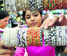 A girl chooses bangles in a Jammu market on Monday