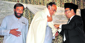 State Finance Minister Abdul Rahim Rather greets a member of Afghanistan-based musical group in Srinagar on Monday.