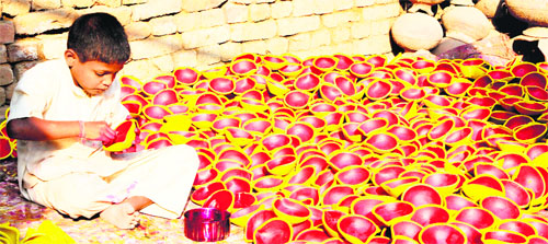A boy paints earthen lamps ahead of Divali in Amritsar on Monday. The festival of lights will be celebrated on November 13.