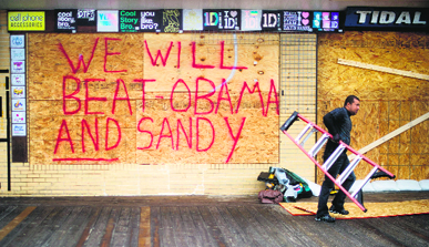 A man carries away a ladder after installing a billboard ahead of Hurricane Sandys landfall in Delaware.