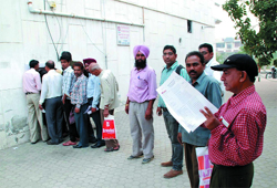 Customers queue up outside a gas agency to submit forms containing details about themselves in Bathinda on Tuesday. The last date for submitting the form has now been extended till mid November. Tribune photo: Pawan Sharma