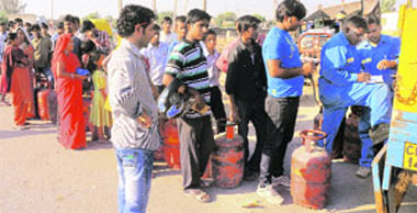 Workers of Bharat Gas Agency distribute LPG cylinders near Sector 16 in Panchkula on Tuesday.