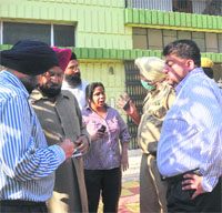 People gather outside the house in Phase 10, Mohali, where the woman was found murdered, on Tuesday