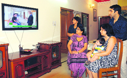 Raznee Diwan(second from left) and her family members watch news to get the latest update on Hurricane Sandy in Sector 48, Chandigarh, on Wednesday. Tribune photo: S. Chandan