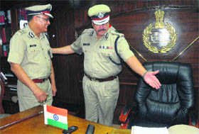 Outgoing police chief RS Dalal (right) hands over charge to new DGP Sriniwas Vashisht at the Police Headquarters in Panchkula on Wednesday. 