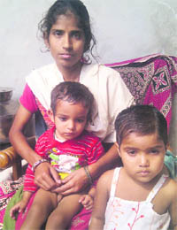 Runa with her two children in her home at Sirsa.