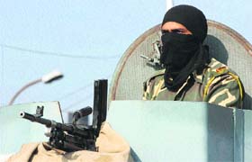 A CRPF jawan atop an armoured vehicle keeps vigil in Jammu