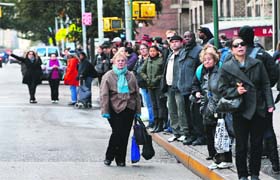 Commuters wait in long queues for a bus in Lower Manhattan after subway service was suspended due to flooding from Hurricane Sandy