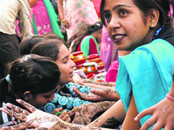 A woman shows off her hands after she gets mehendi done in Jammu on Thursday.  