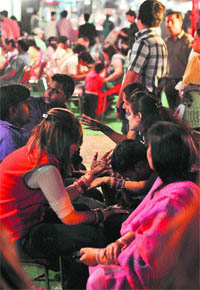 Henna artists apply mehndi on the hands of women on the eve of Karva Chauth in Ludhiana on Thursday. 