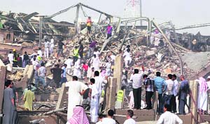 People walk among rubble at the site of a fuel truck explosion in Riyadh, Saudi Arabia, on Thursday