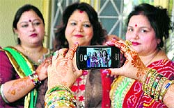 Women during a Karva Chauth function in Jammu. Here a woman is taking a picture with her mobile camera