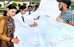 A team of Lally Infosys holds a signature campaign against corruption in Jalandhar on Friday
