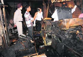 A forensic team inspects a gutted machine at a Sector-22 shop in Chandigarh on Saturday