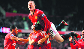 Manchester Uniteds Wayne Rooney celebrates after Robin van Persie scored during their Premiership match against Aresnal in Manchester on Saturday.
