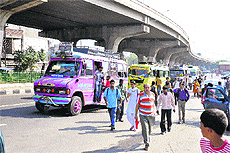 Passengers alight from a mini bus stopping bang in the middle of a road in Jammu.