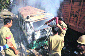 Firemen try to douse flames after a fire broke out in trucks parked in a warehouse in Jammu. 