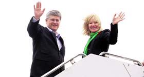 Canadian Prime Minister Stephen Harper and his wife Laureen wave to the crowd while boarding plane in Ottawa on Sunday.