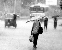 People walk in rain caused by Cyclone Nilam in Vijayawada district of Andhra Pradesh.
