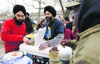 Sikh volunteers serve a hot meal in a park in the Rockaways, a neighbourhood that was devestated by superstorm Sandy and is still without power in the wake of the storm, in New York.