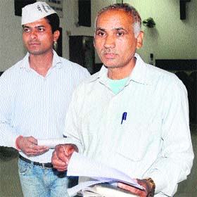Complainant OM Prakash (right) at the UT Secretariat in Sector 9, Chandigarh, on Monday