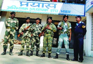 Security personnel guard the strong rooms where electronic voting machines are kept after the Vidhan Sabha elections, in Dharamsala on Monday.