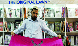 A shopkeeper displays clothes during the CII fair in Ludhiana.