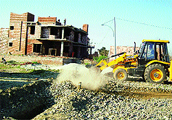A bulldozer at work in an unauthorised colony in Ludhiana. 
